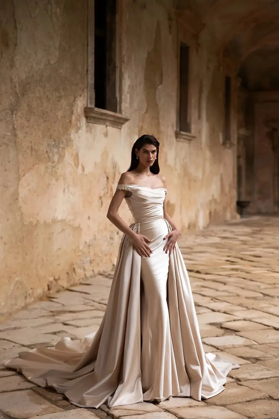 Model is wearing a satin cappuccino sheath wedding dress with an overskirt by eva lendel
