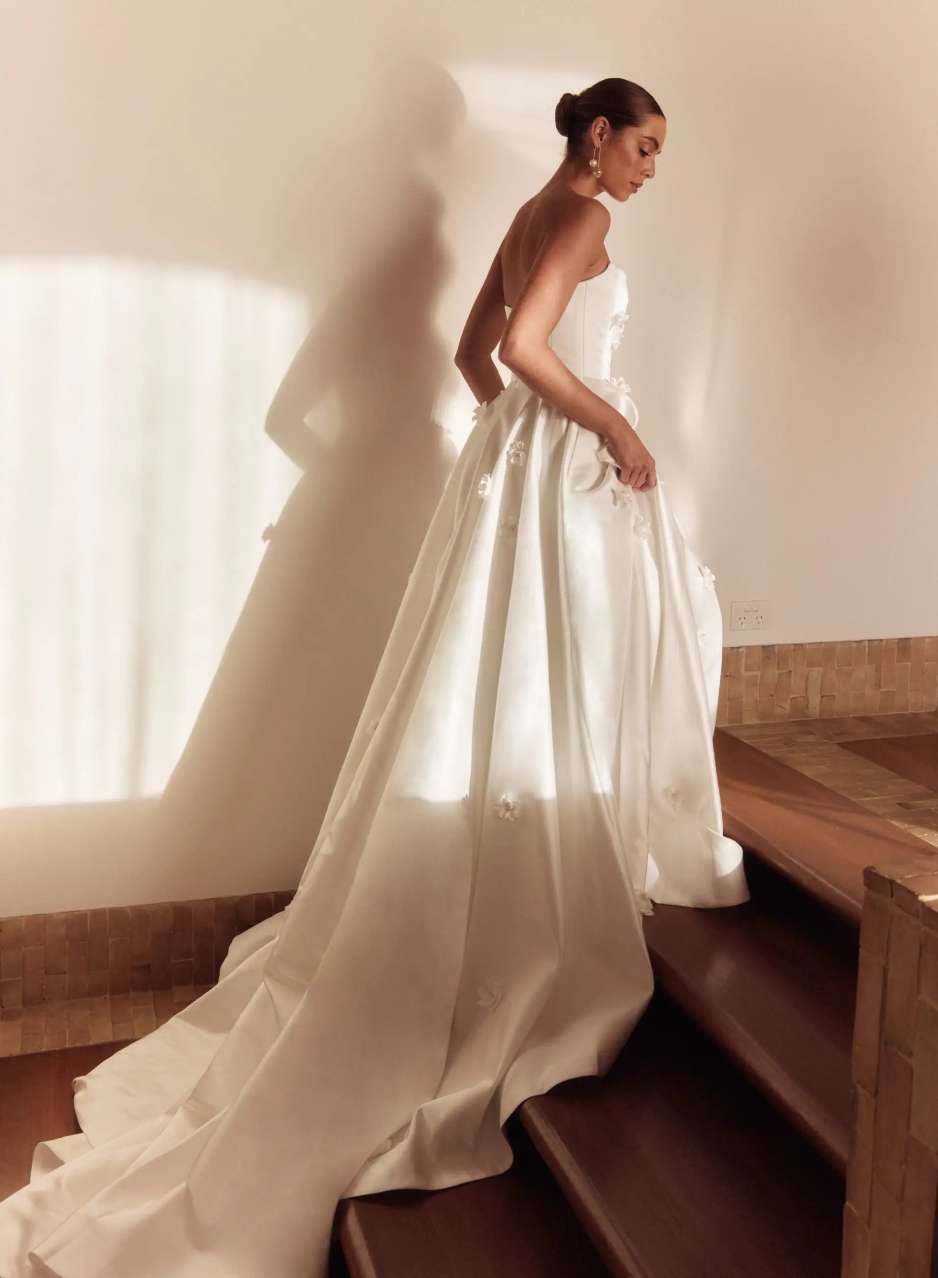 Model is wearing a ball gown wedding dress with 3D handmade flowers and made of italian silk satin by alena leena