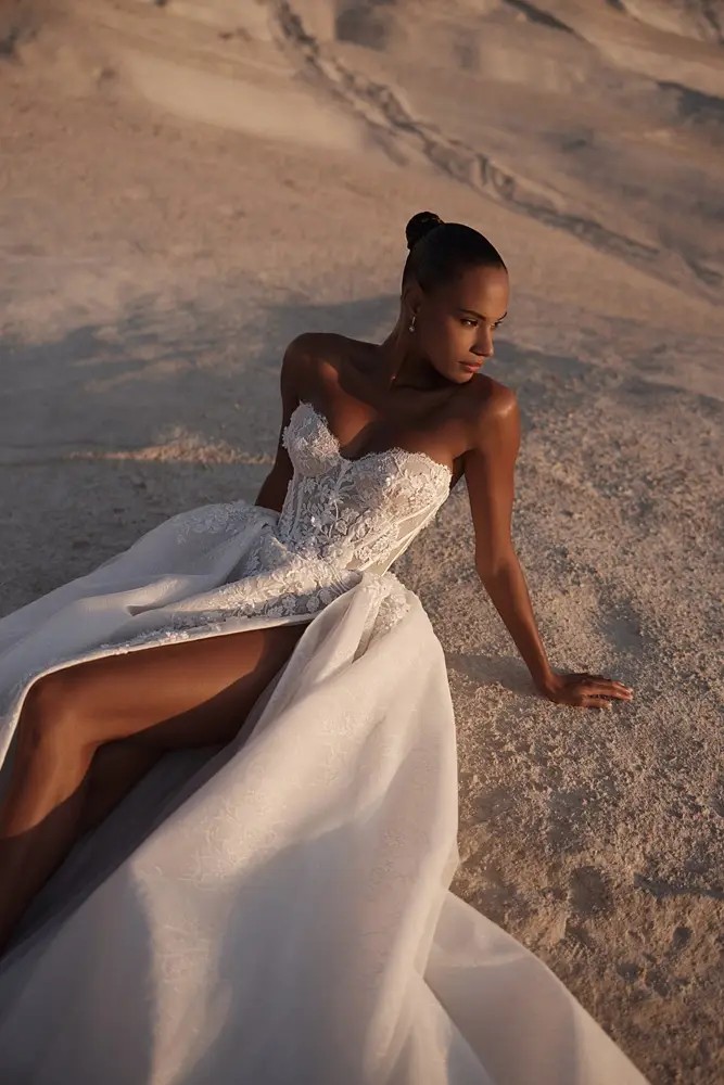 Model is wearing a classic sweetheart corset wedding dress with a slit by eva lendel